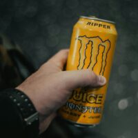 person holding yellow and black can